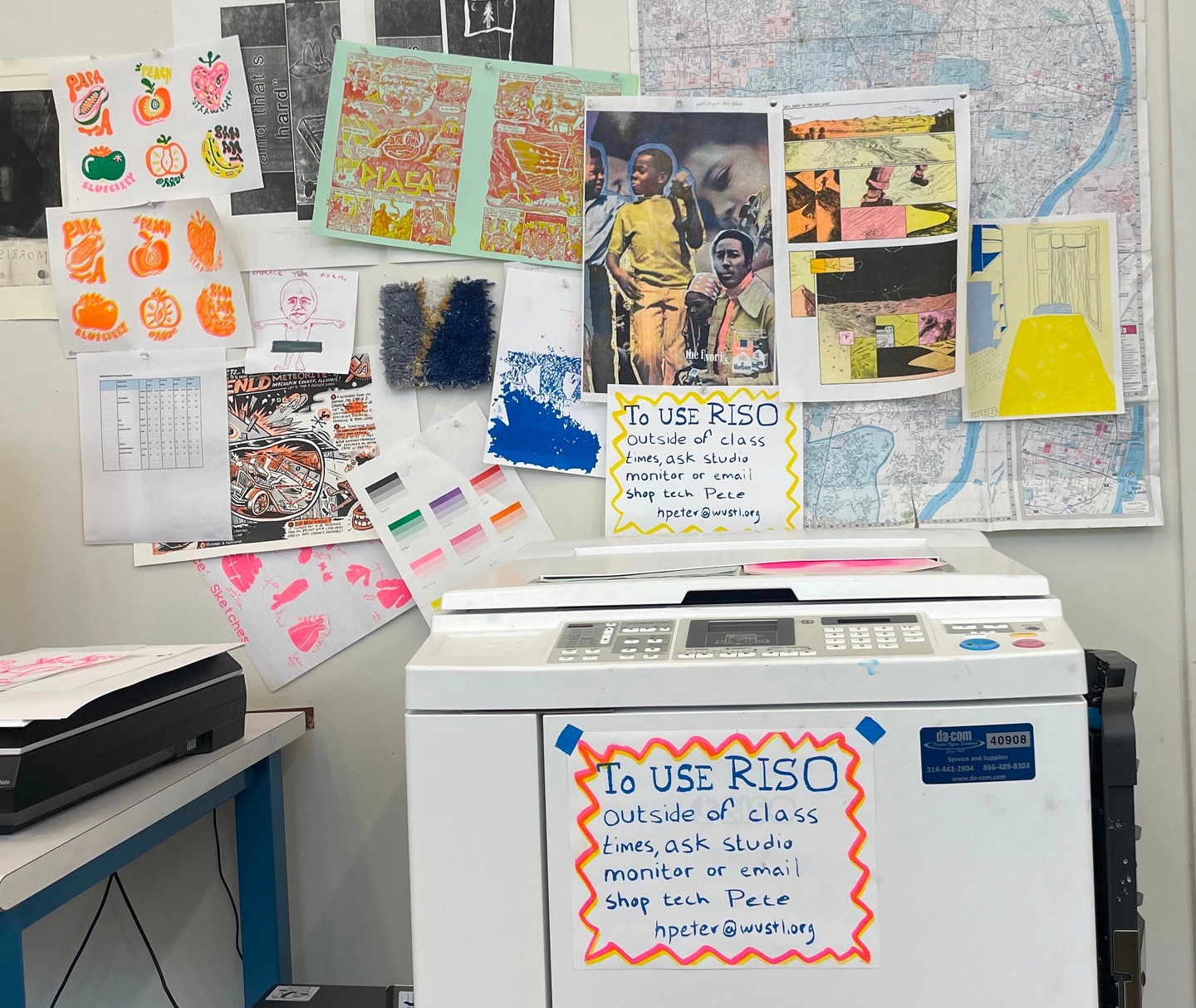 Photo of the risograph printer in the printmaking studio. The wall behind is decorated with various traditional prints including risograph