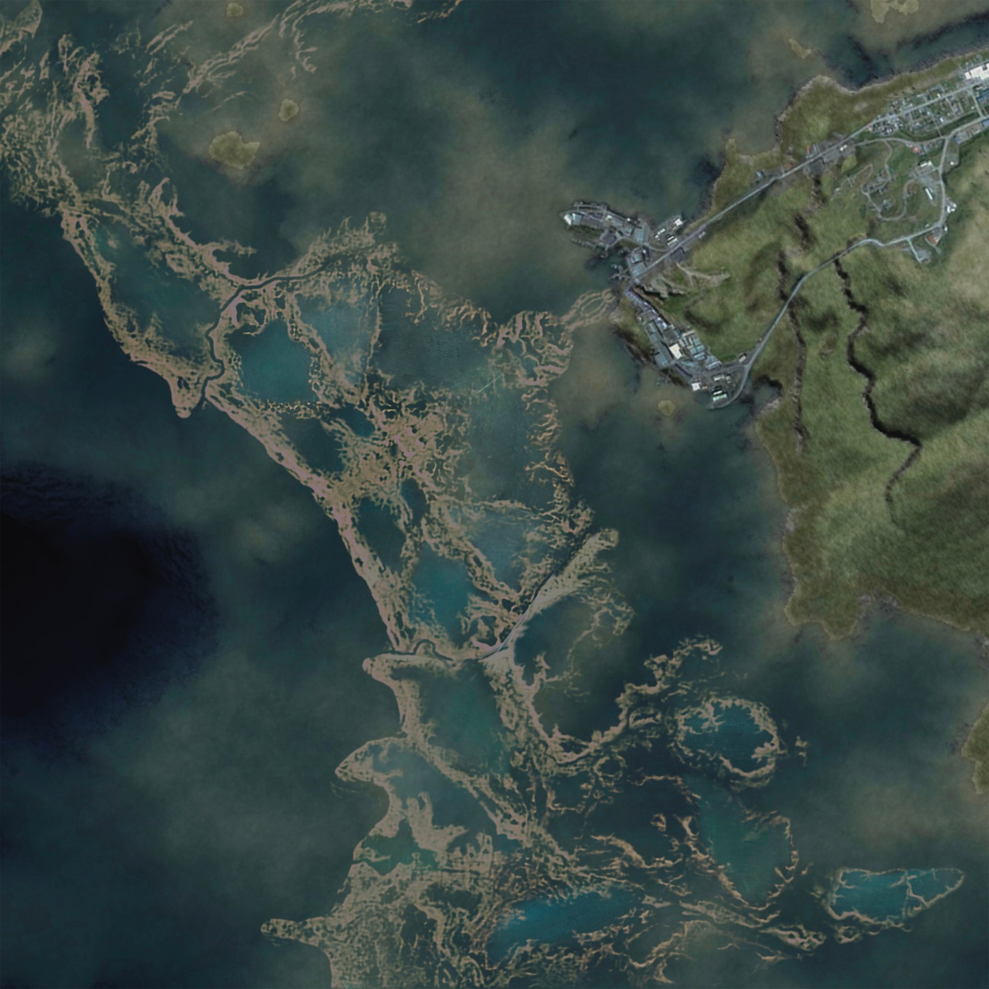 Aerial view of a coastline in dark blues and teals.