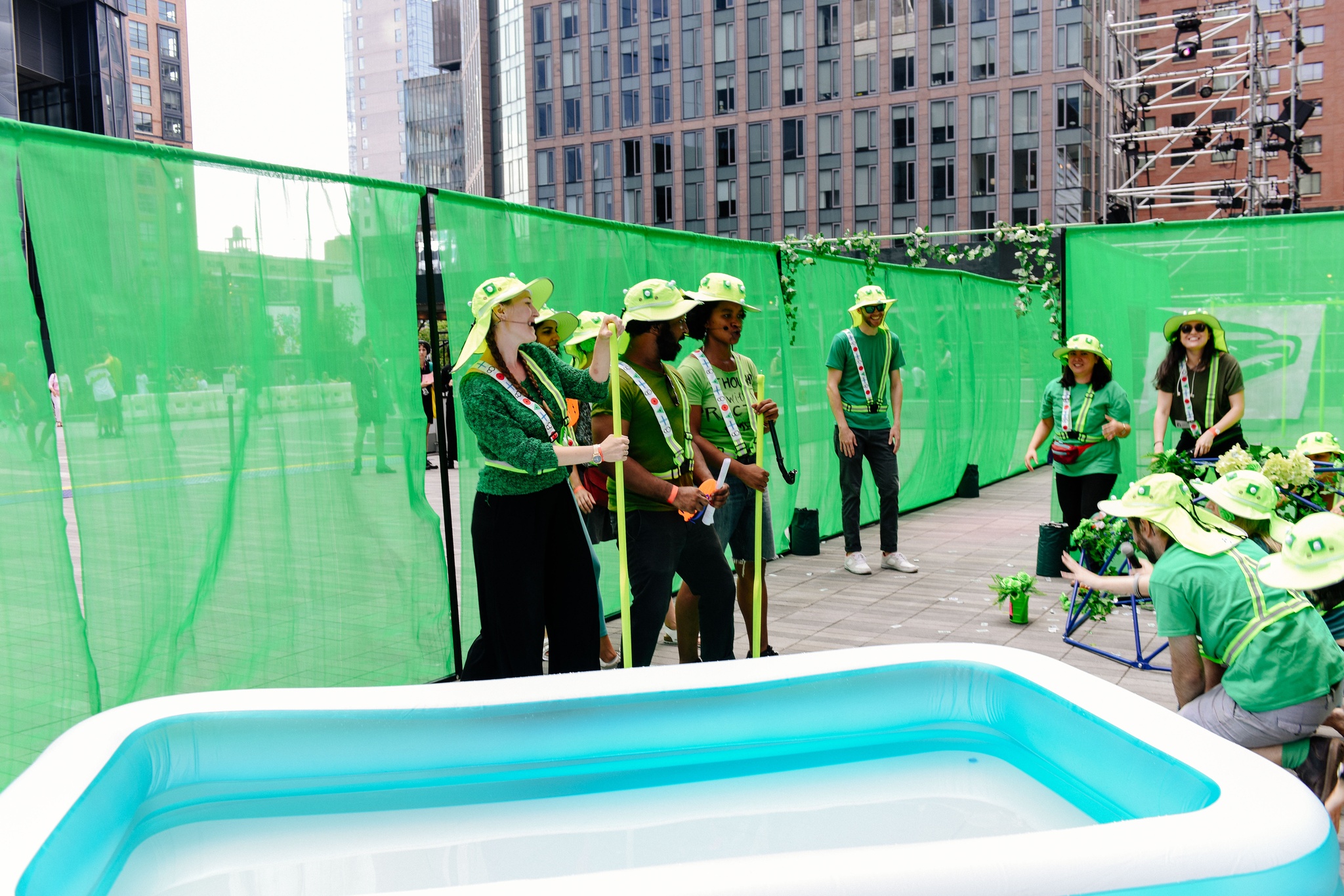 A group of participants in green hats around a kiddie pool.