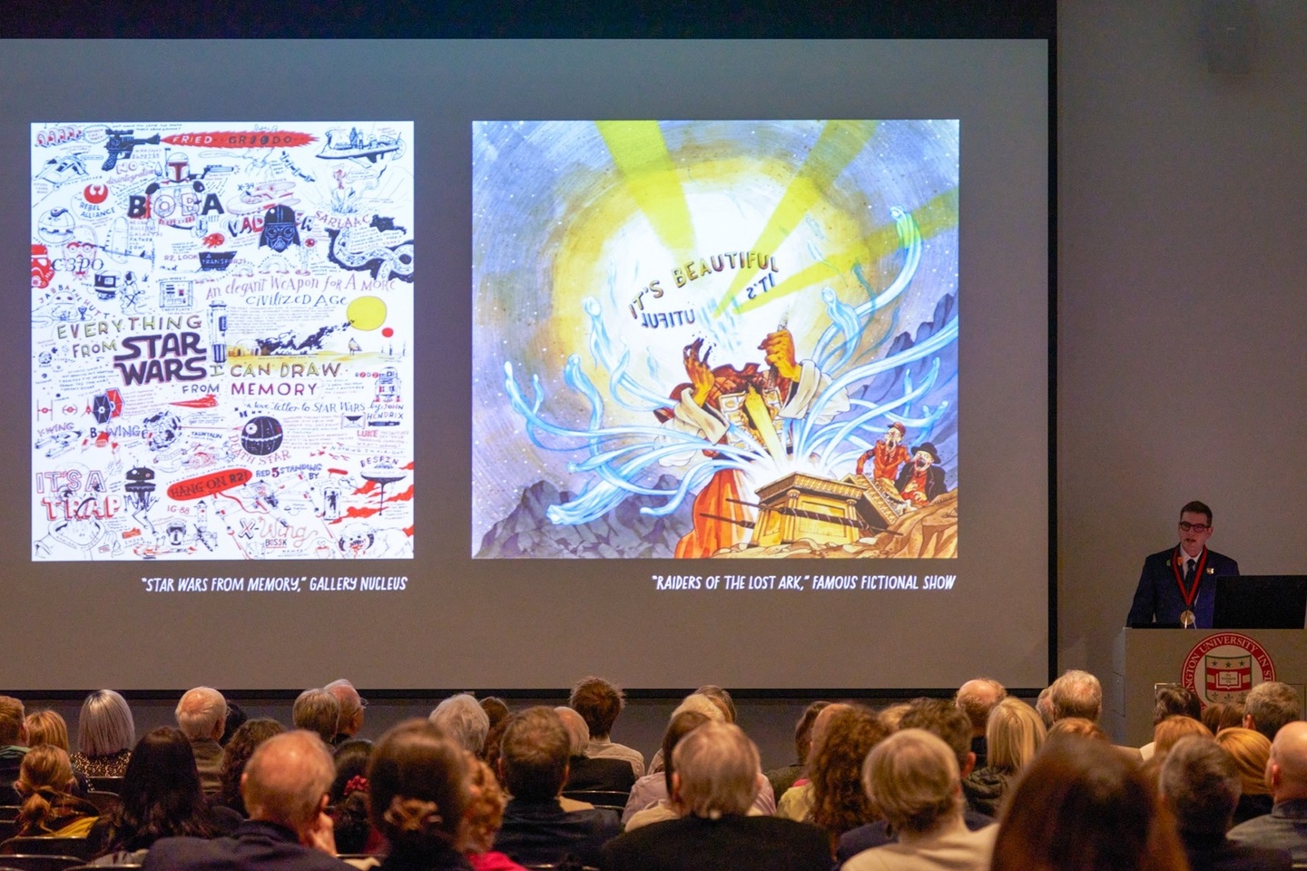 Auditorium of people with professor at front delivering lecture and two images on projection screen of illustrations.