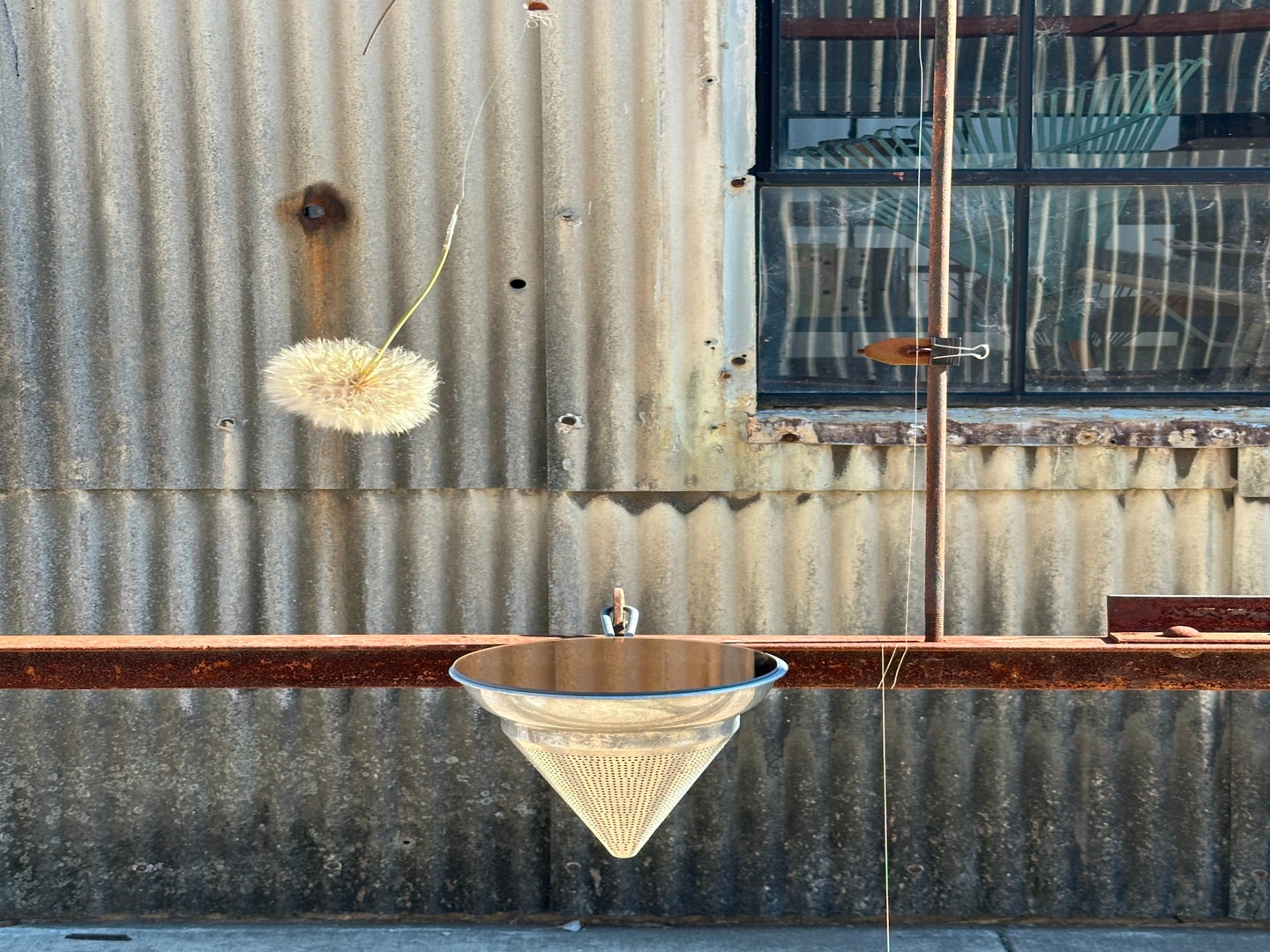 a colander attached to a wooden rail