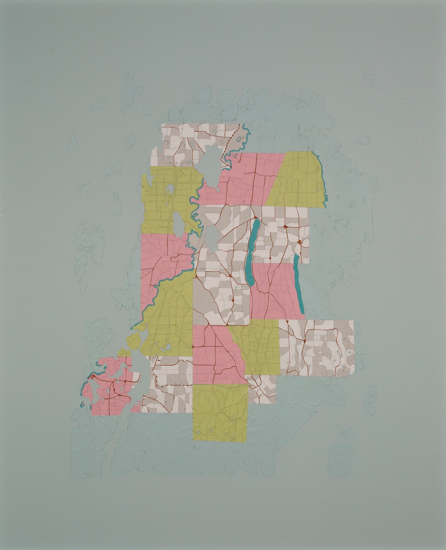 Fragments of colored paper form a map-like shape on a blue ground