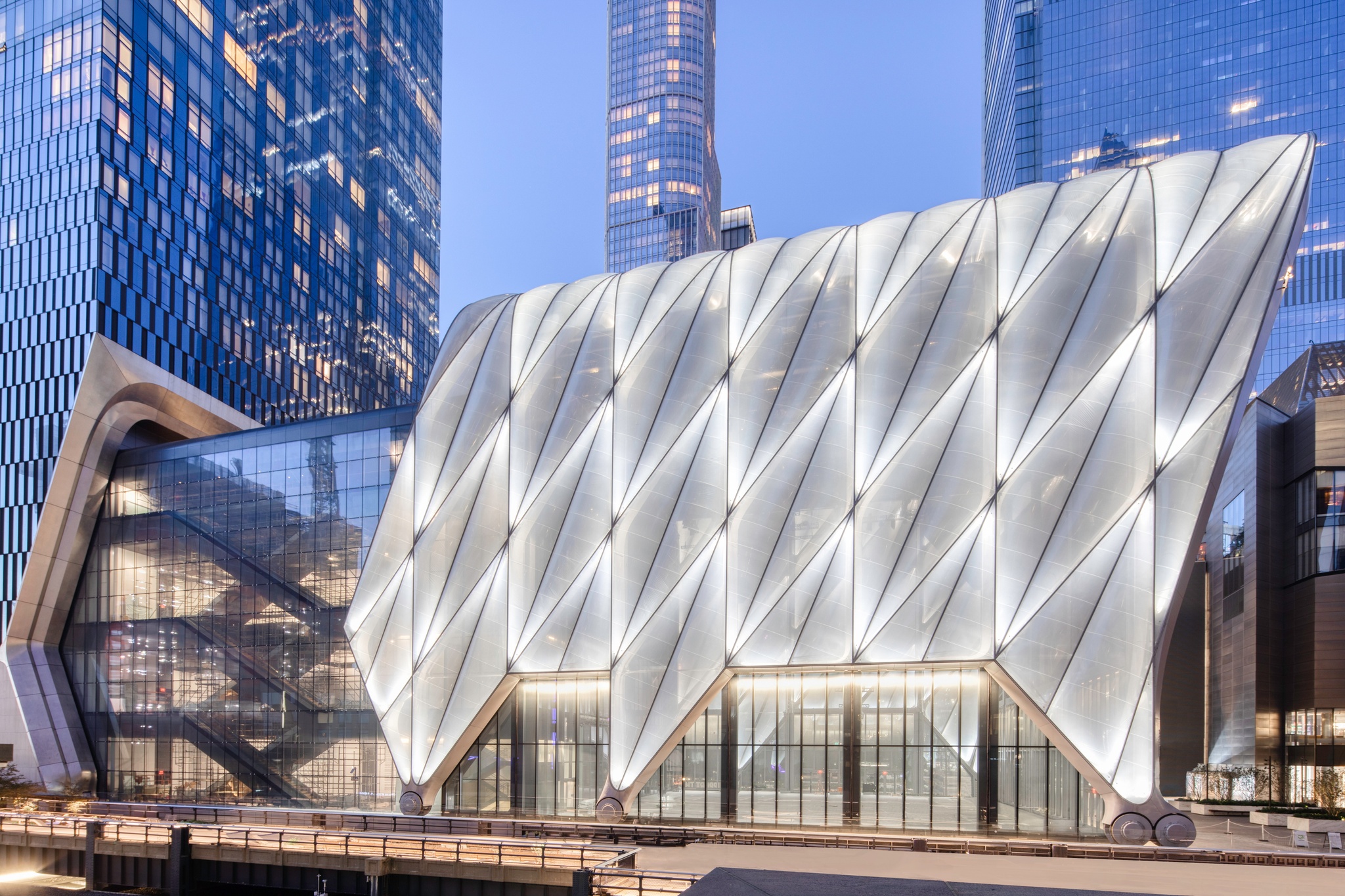 The Shed's south-facing façade at dusk, with the building's movable shell lit and glowing from within