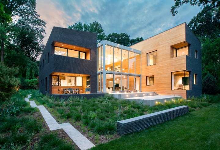 Exterior photo of a modern residential home amidst trees and grass