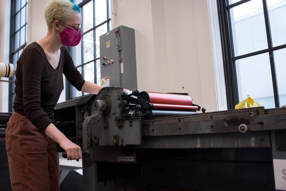 Low angle shot of a person operating a roller press.