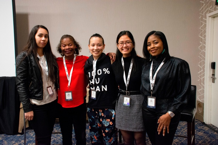 5 people wearing lanyards posing for a photo