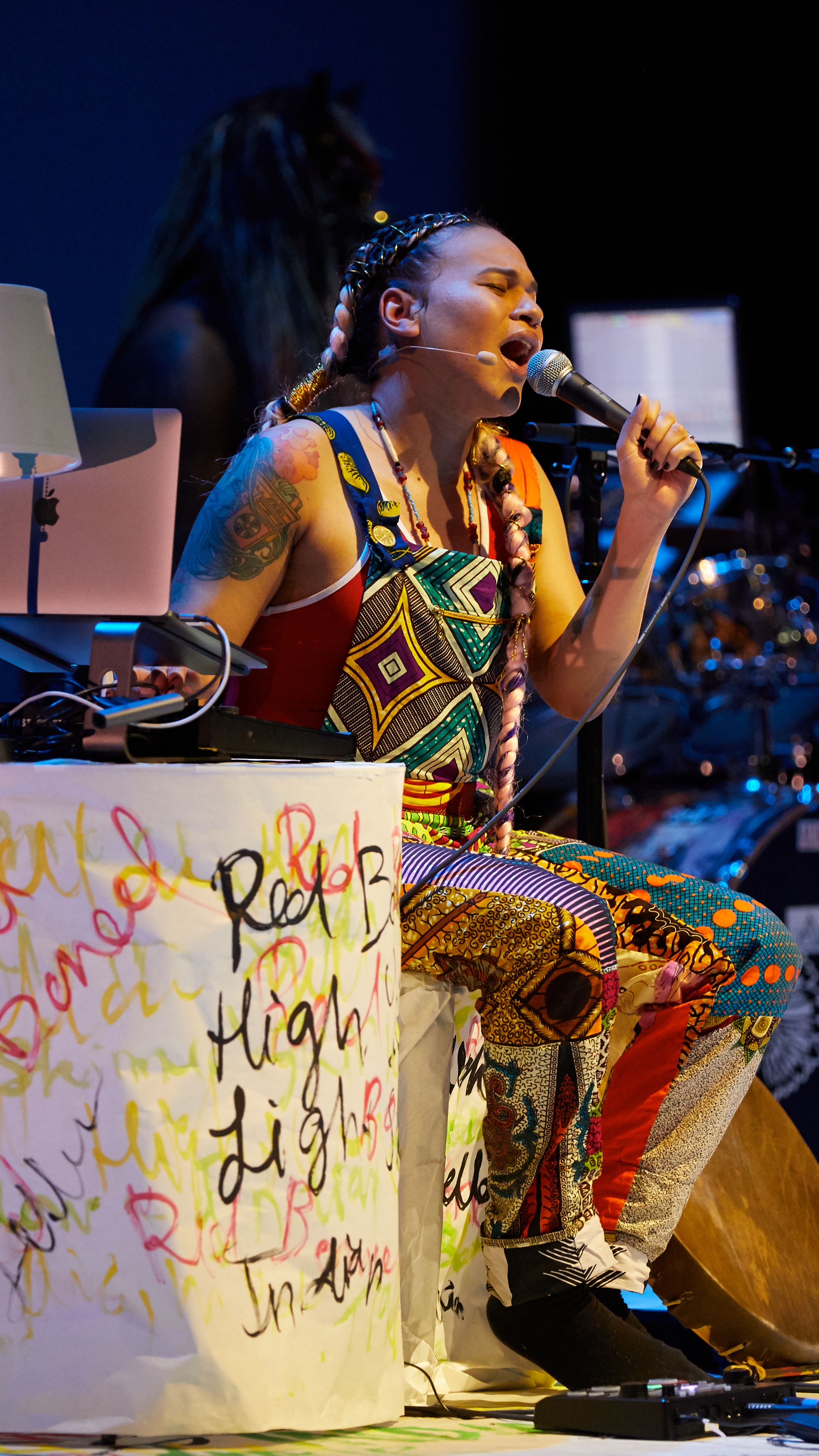 Kelsey Pyro singing while playing electronic instruments.