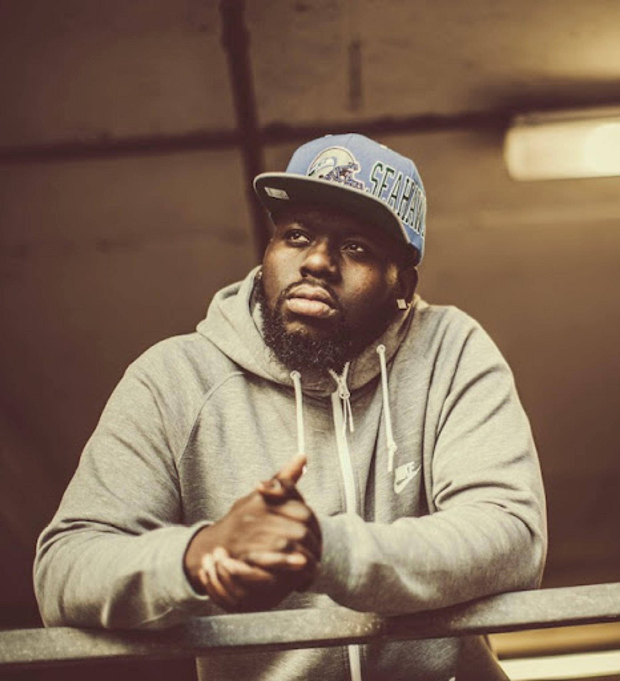 Photo of man leaning on a balcony.