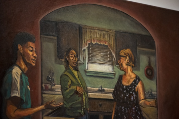 Detail of a painting of two women talking in a homey-looking kitchen. A teenage boy stands by the doorway speaking to someone offscreen.