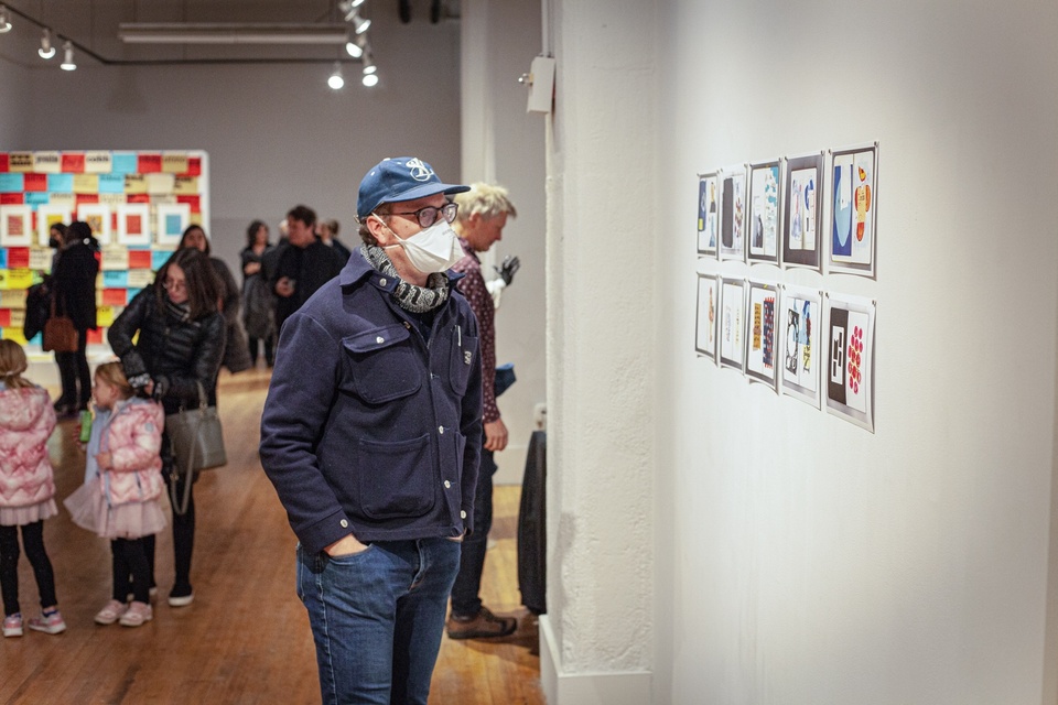 A visitor looks at the artwork on the wall 