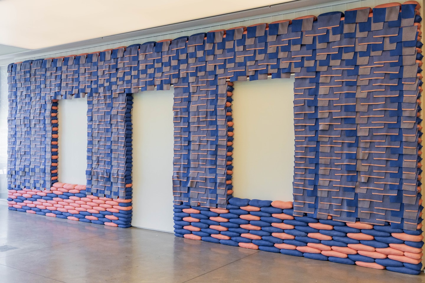 blue and orange sandbags secured against a wall with two openings for windows and one for a door