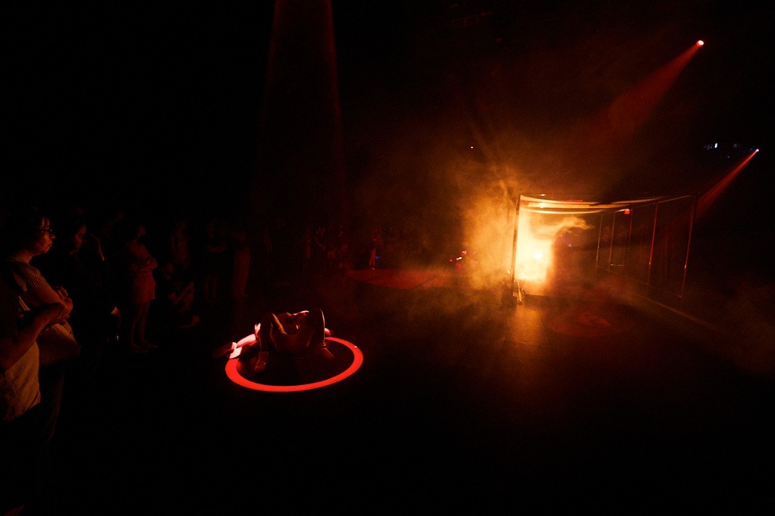 Dancers on a dramatically lit stage in front of a crowd.