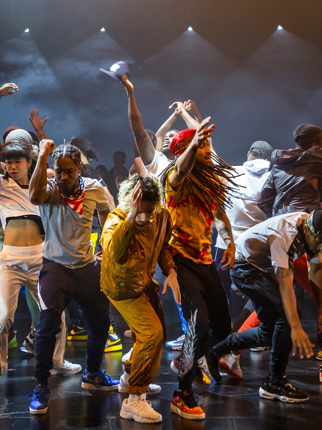 Maze dancers gathered together dancing in the middle of a black box theater