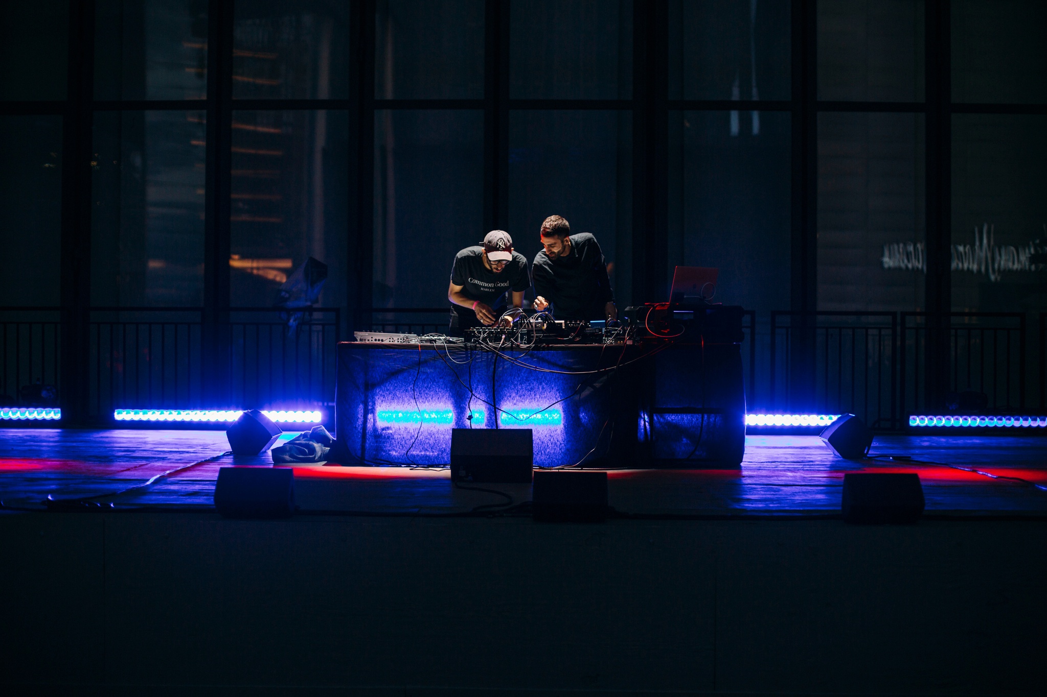 Two men behind an electronic DJ set up.