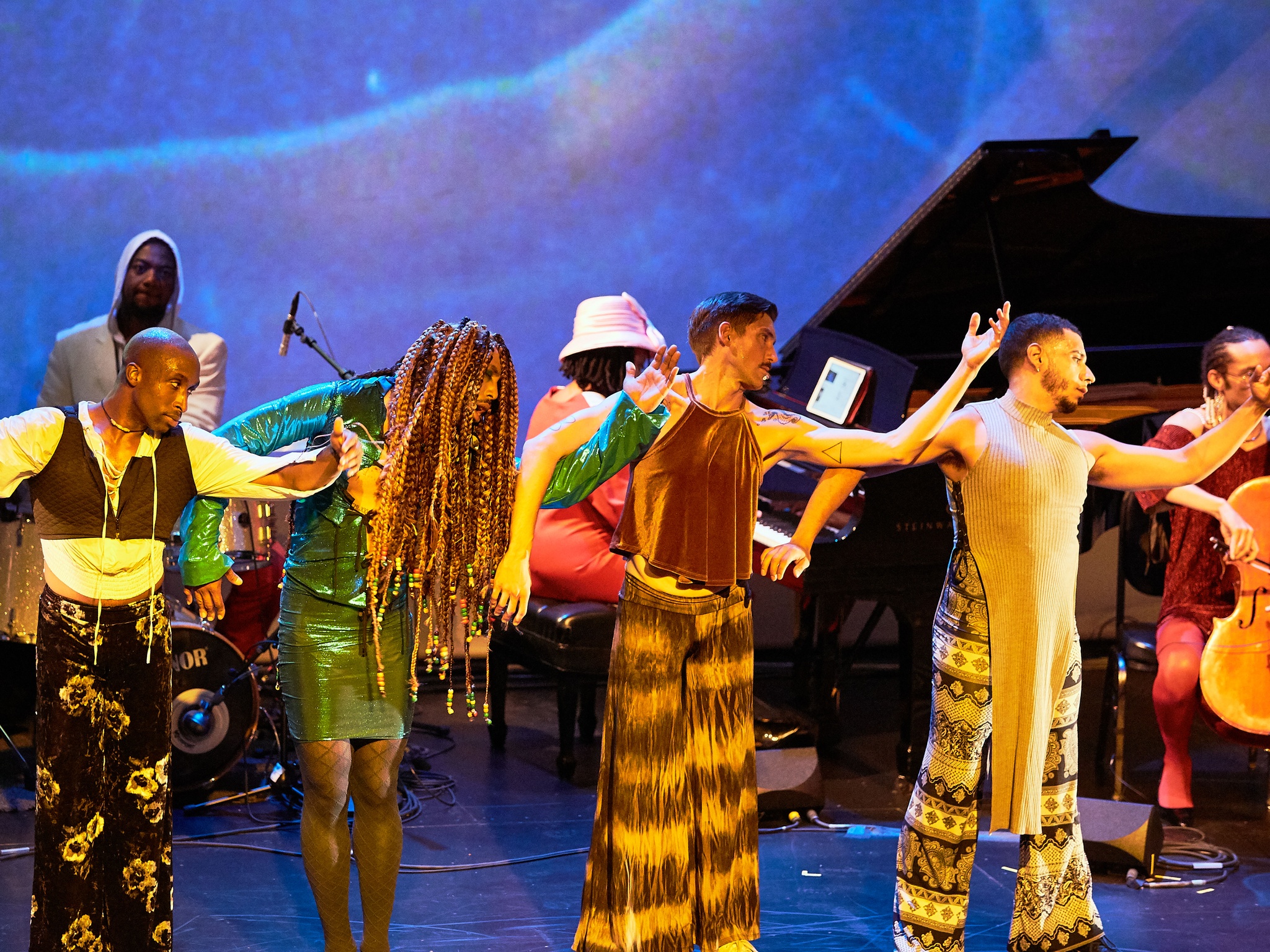 Four dancers performing on a stage.