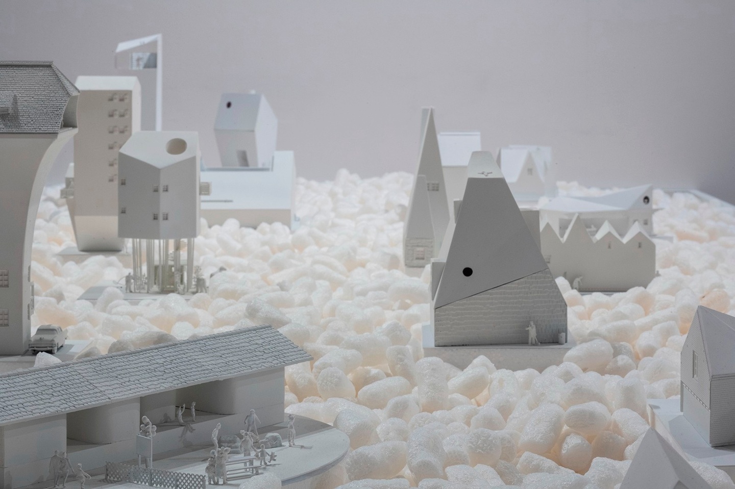 model of all white buildings scattered around surrounded by packing peanuts