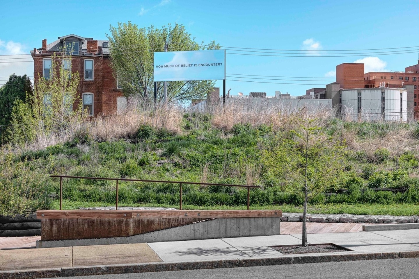 an urban park like scene with a billboard that reads, "How much of belief is encounter?"