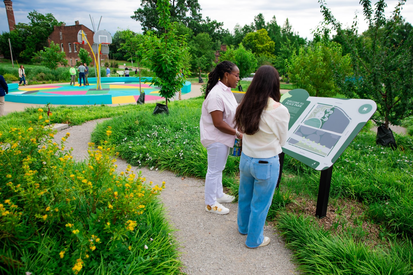 people reading at a sign in Peace Park