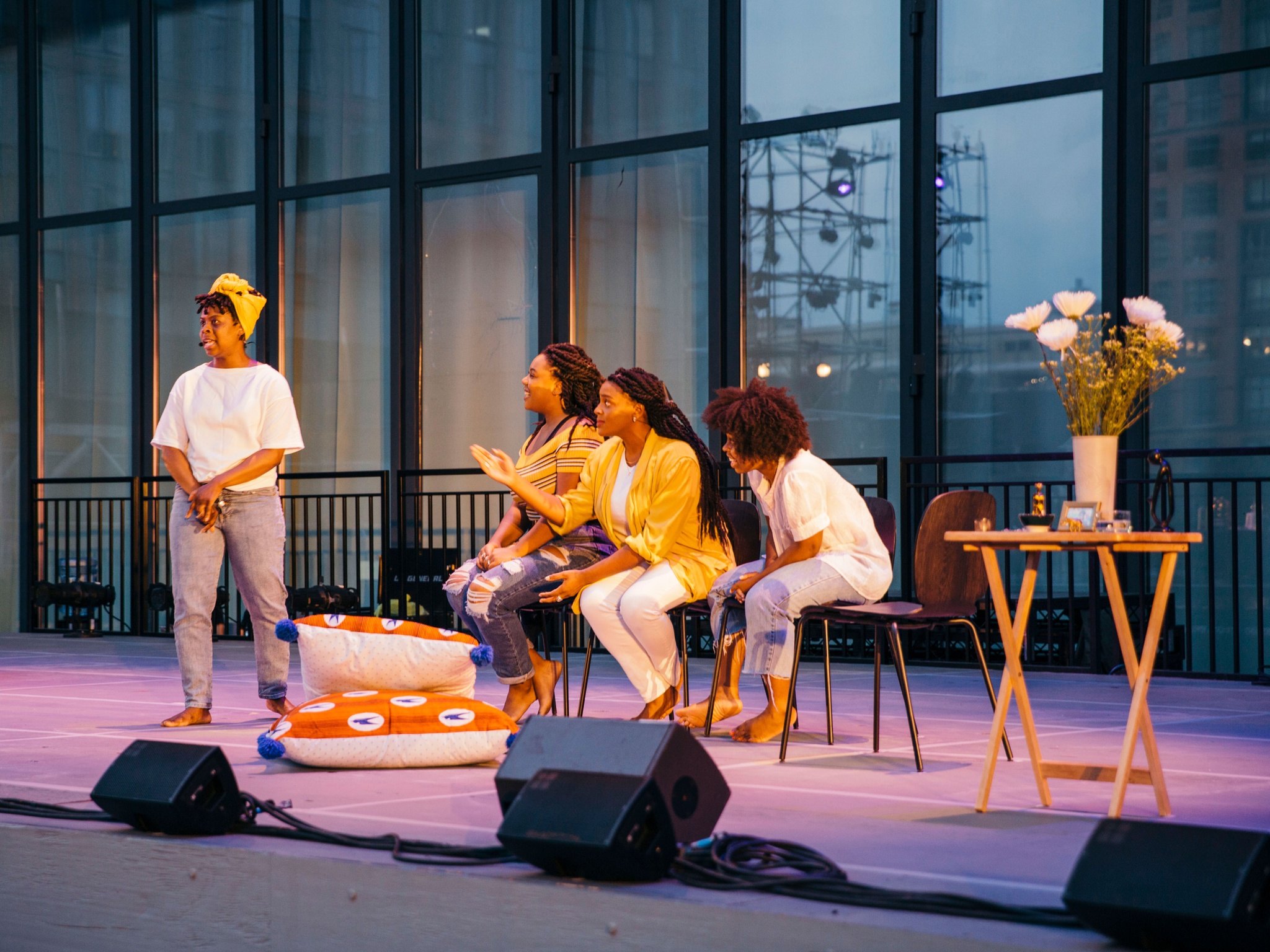 Four women acting on stage barefoot.