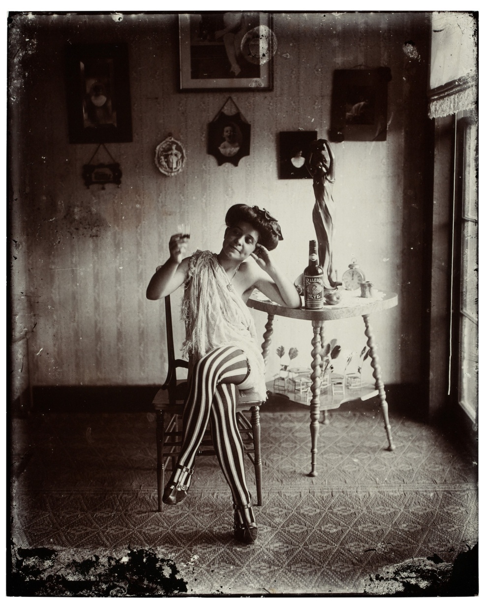 black and white photo of a figure sitting on a chair in the middle of a room