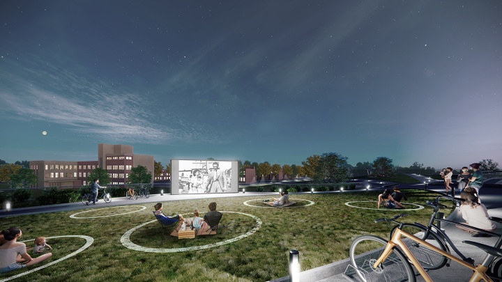 Evening rendering of an open-air theatre, with people seated on the grass outside, some in circular marked areas on the ground, watching a film on a big screen.