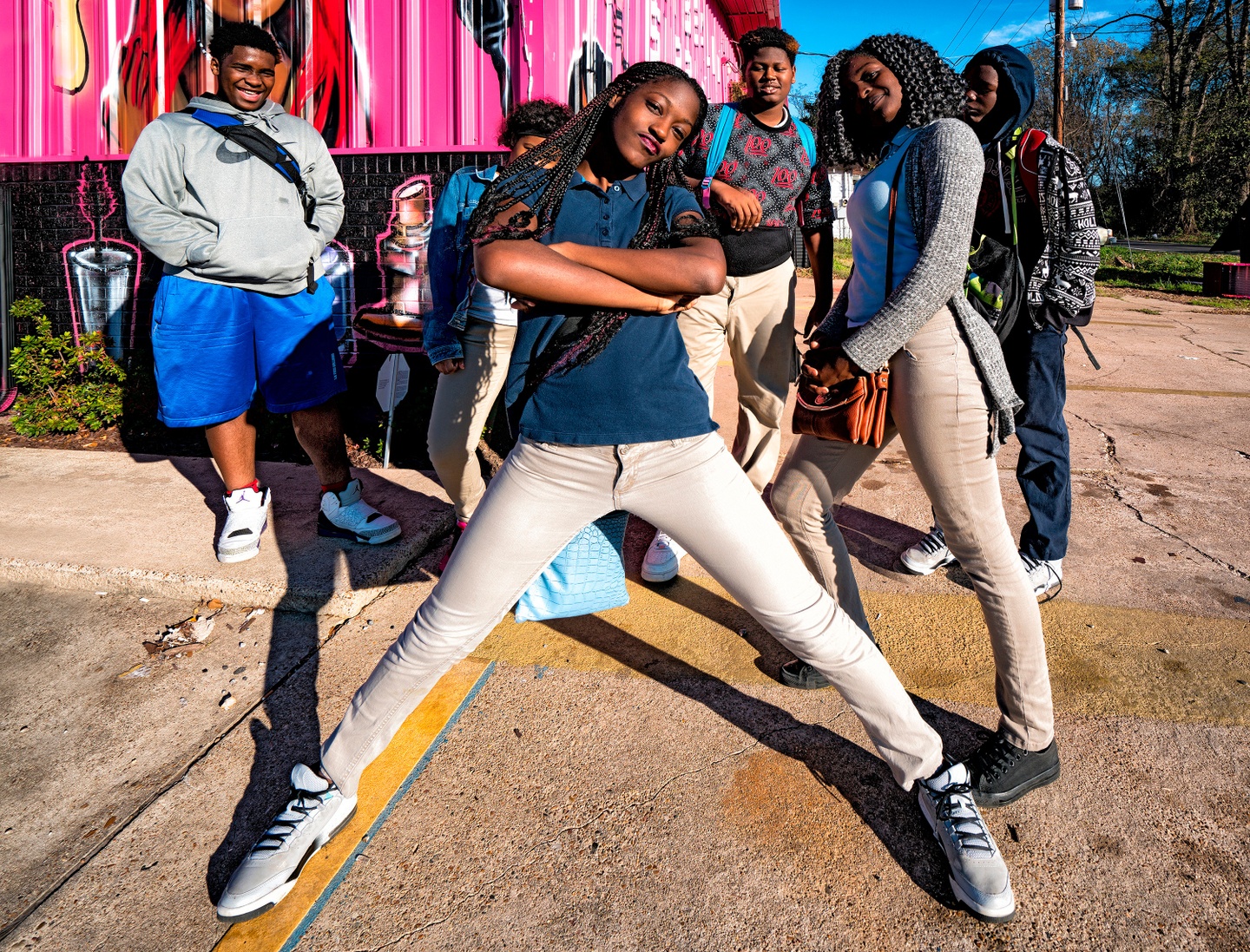 A group of young people pose for the camera in front of a colorful background