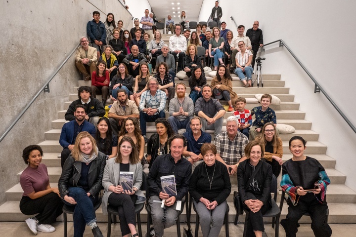 Group photo of the attendees and panelists gathered together on the Pulitzer's risers.