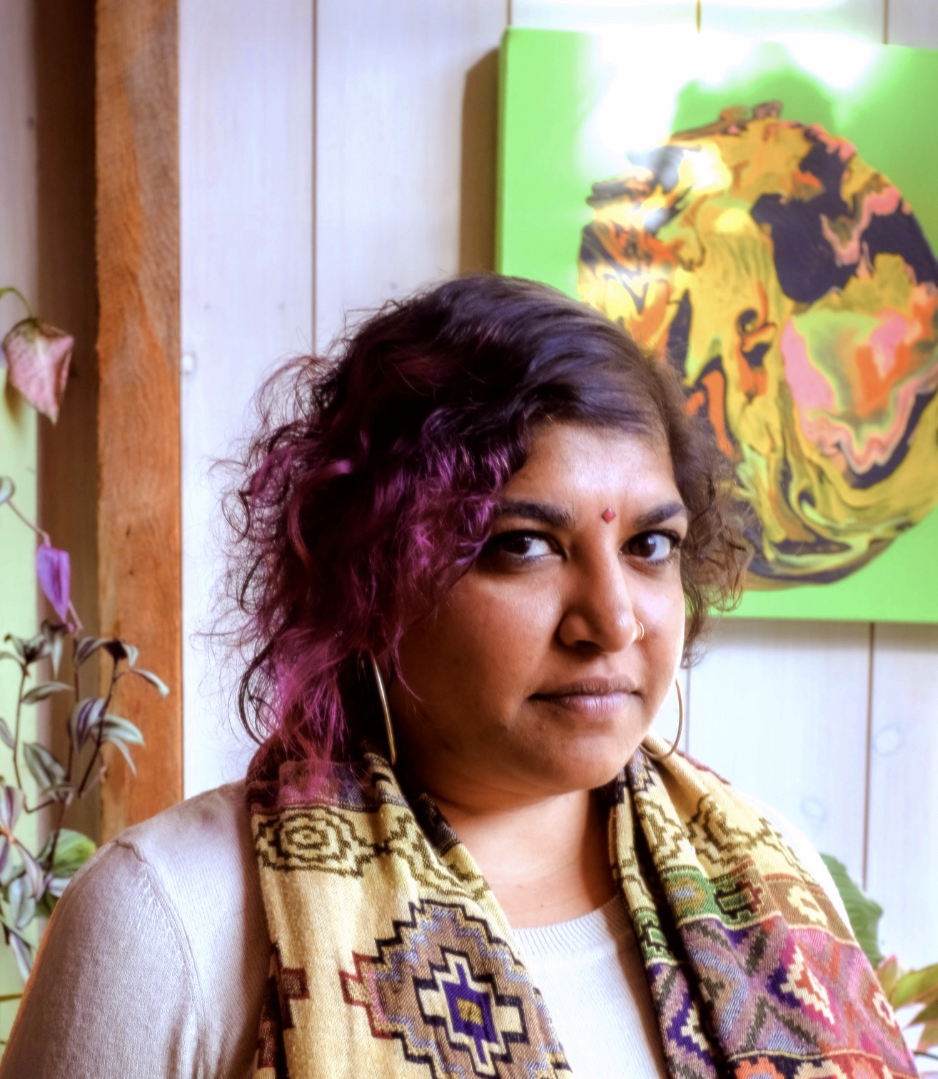 A photo of Sheetal Prajapati, who had pink highlights in her hair and wears a scarf around her neck. 