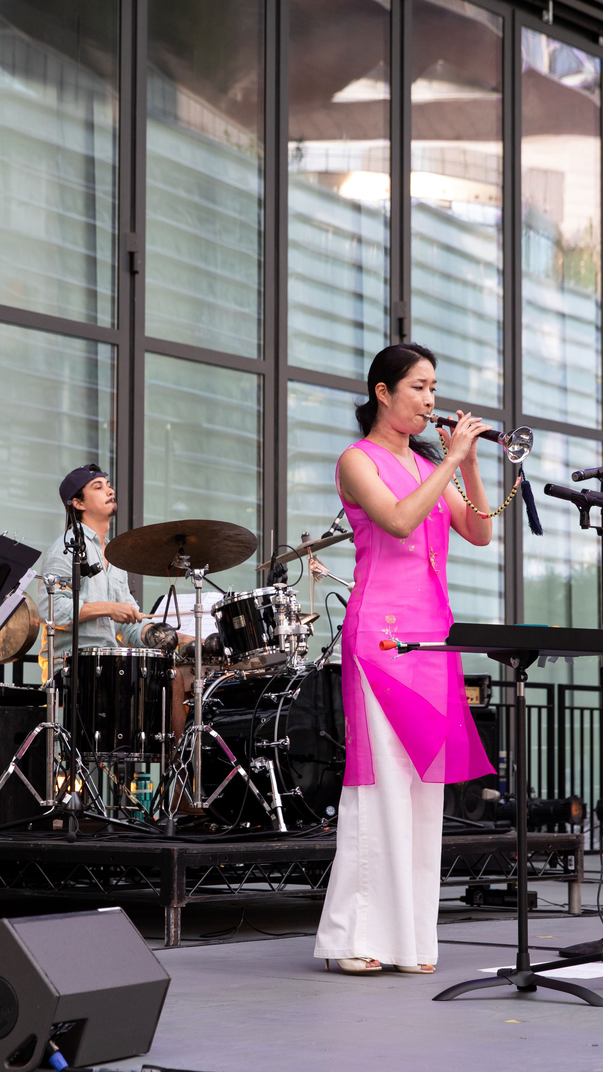 Woman and man playing live instruments on a stage.