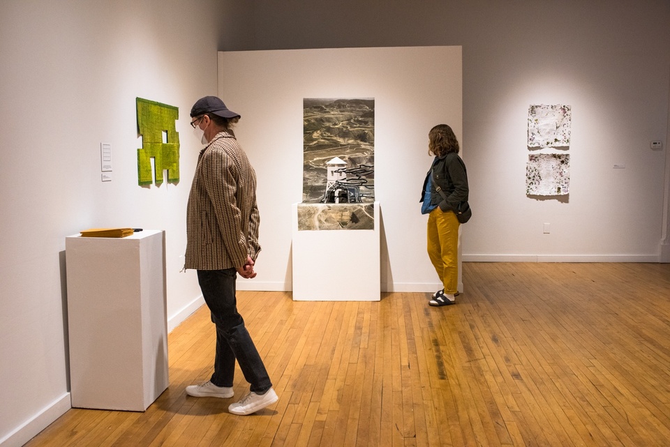 Two people in a gallery space viewing work.