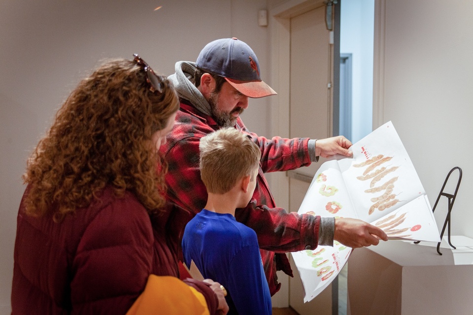 Visitors flip through a large zine