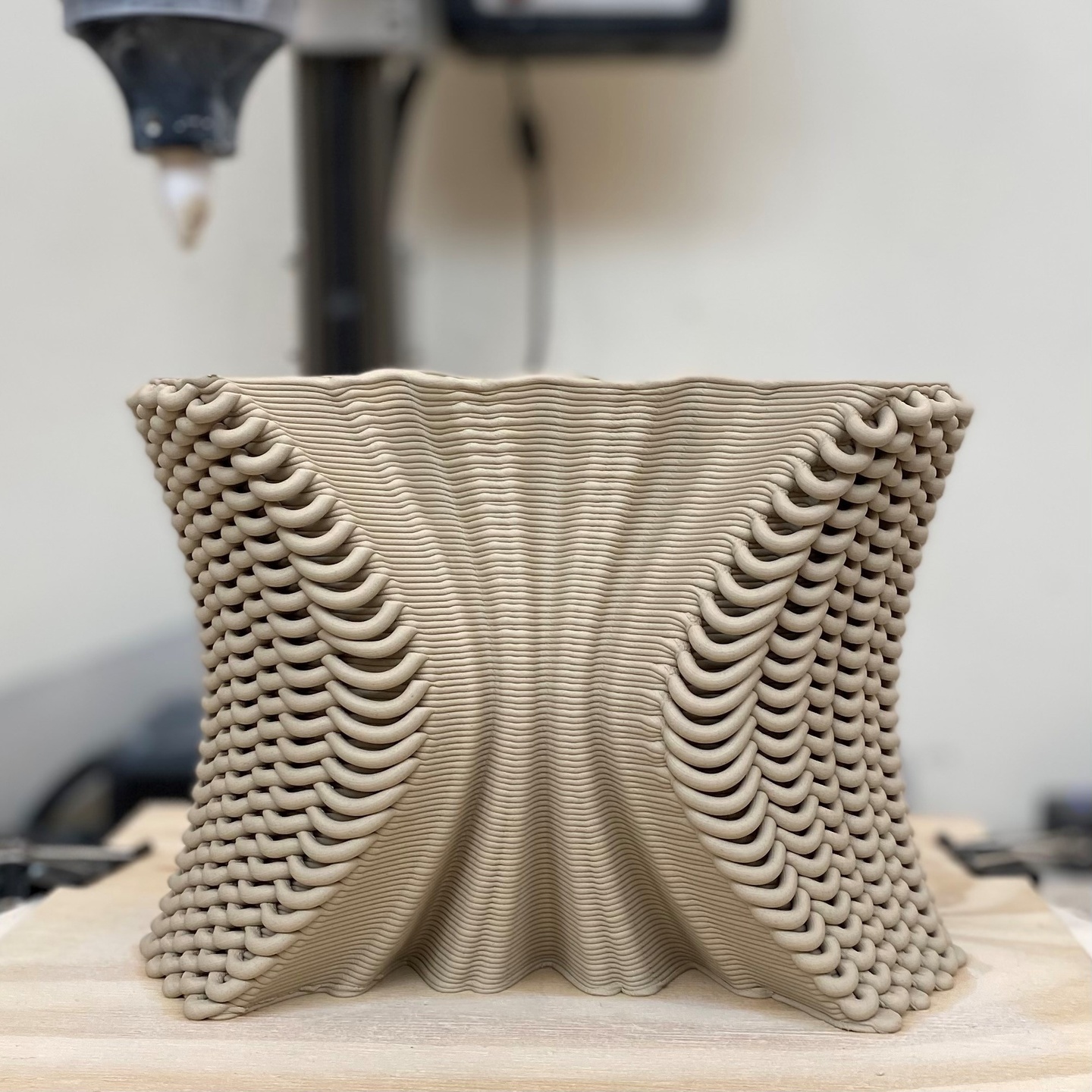 3D printed model of a segment of a masonry screen wall with a patterned, textured surface of curves.