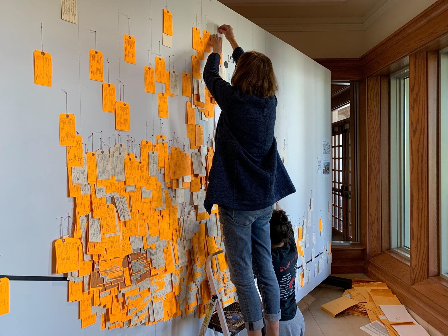 Two people pinning yellow tags to an enlarged map