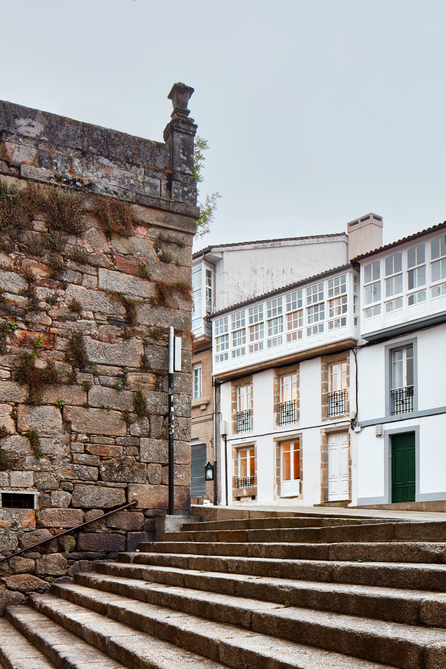 Cobblestone stairs leading up to the white apartments accented with large windows.