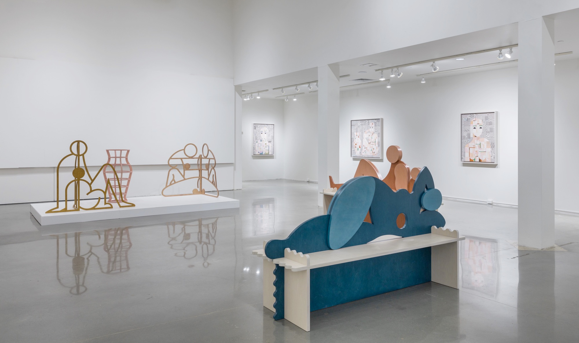 Multiple abstract figures arranged in various poses staged throughout a white room. Three abstract paintings of figures line the back, right wall of the gallery.