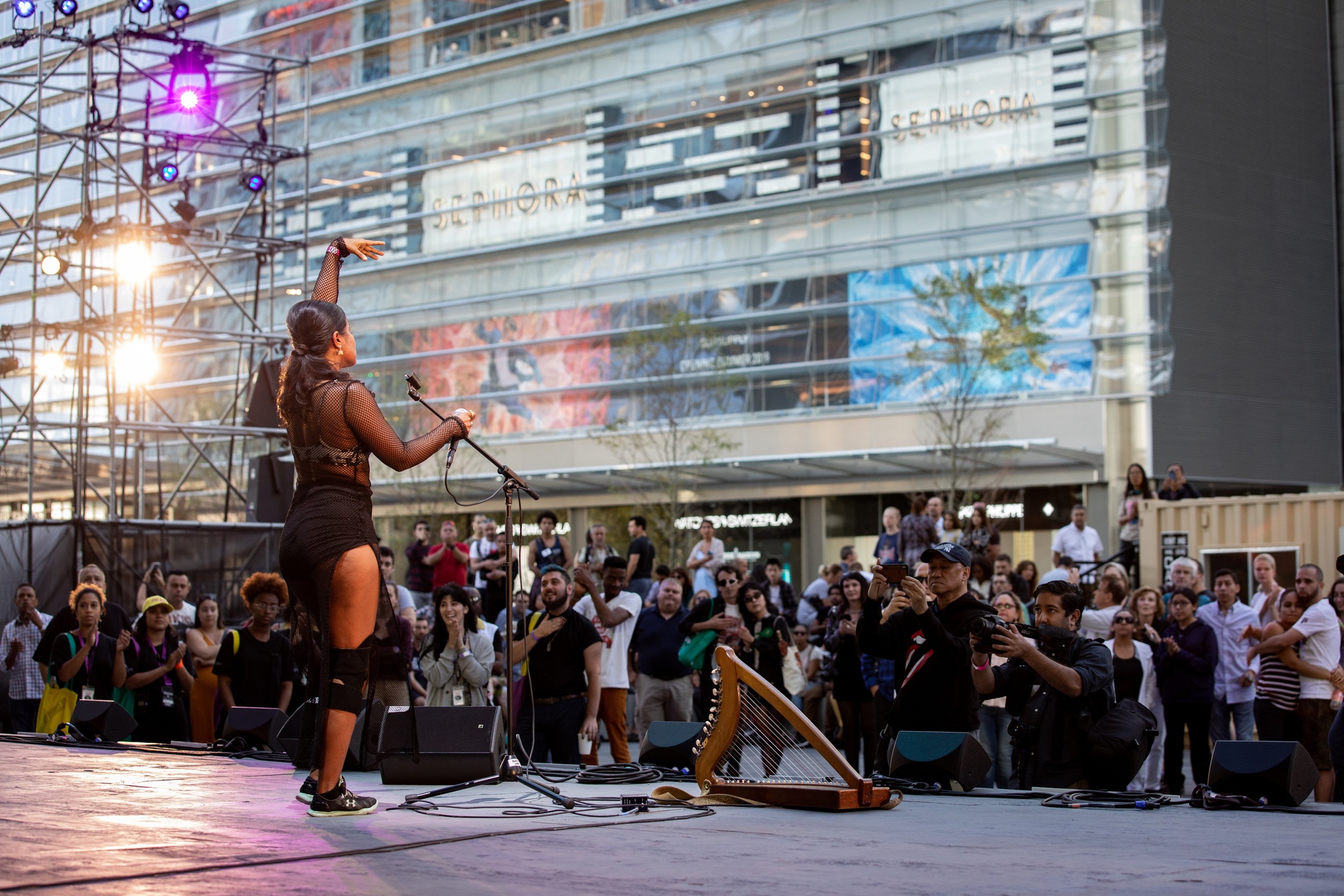 Singer singing on outdoor stage.