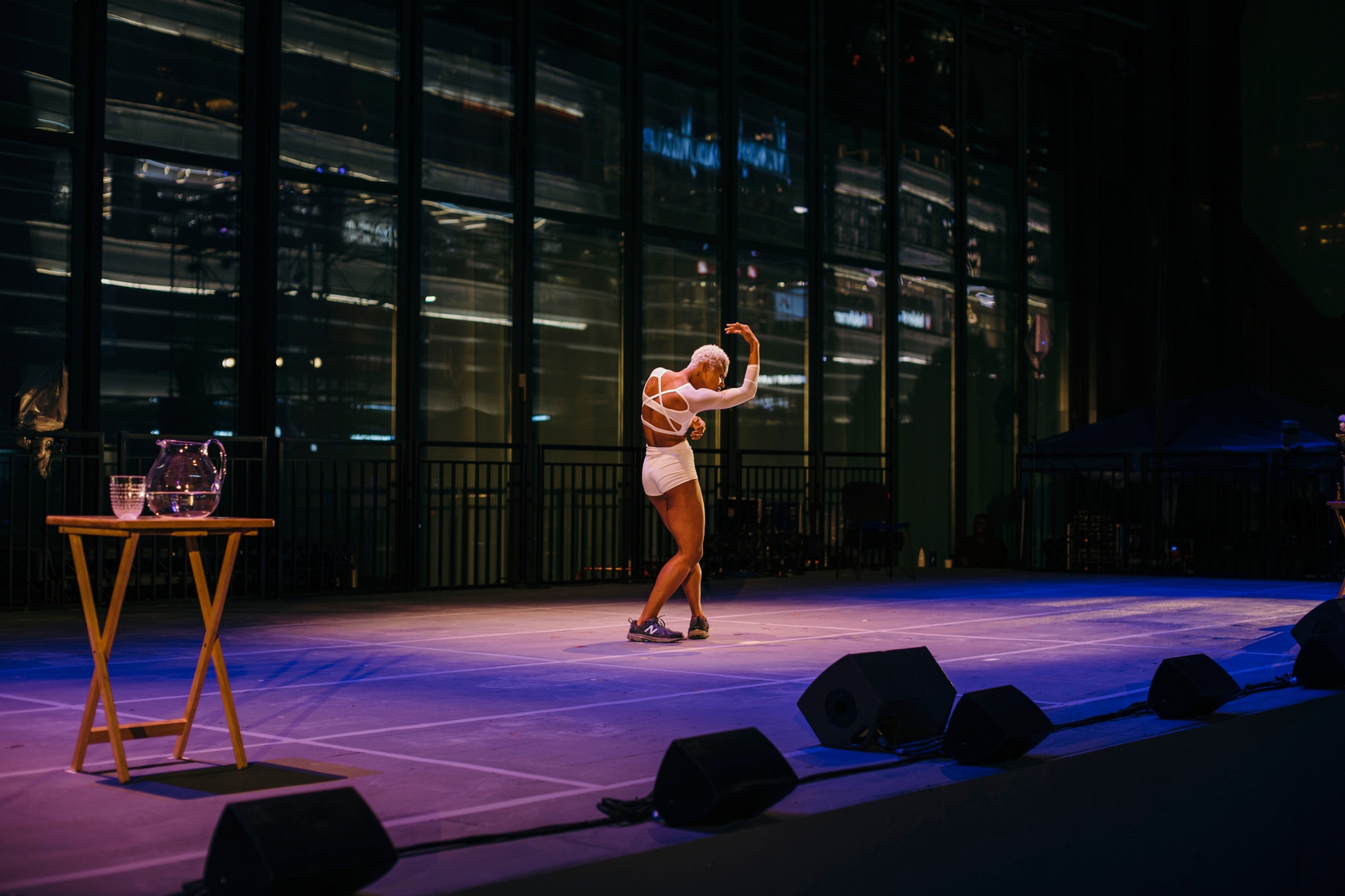 Woman dancing on a stage at night.