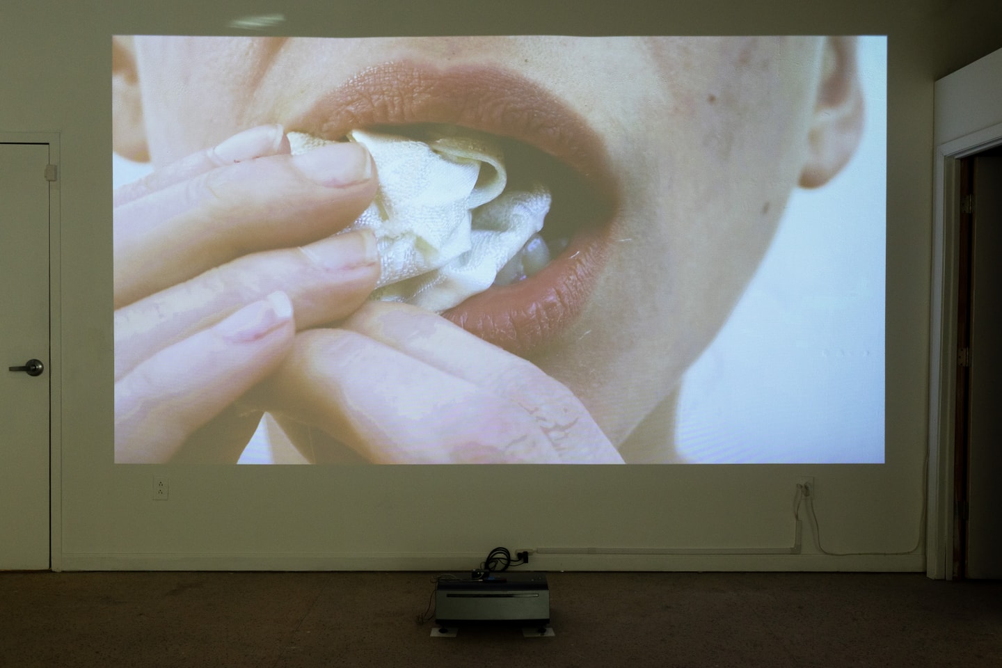 still of a film of a woman putting paper in mouth