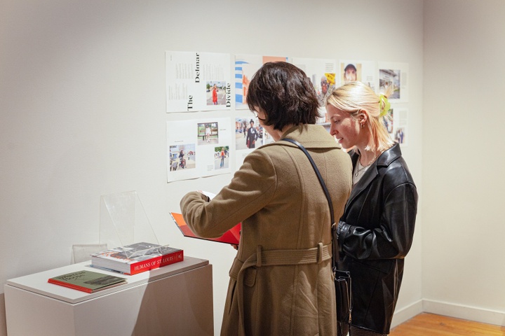 Two visitors flip through the Humans of St Louis book