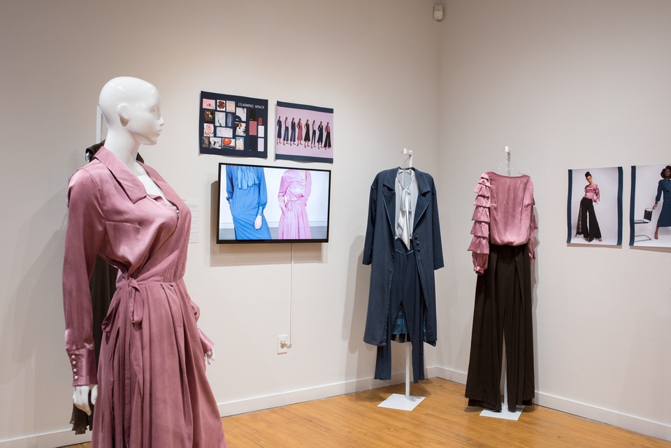 Three garments from a collection. Business casual attire including a mauve wrap dress, a long navy coat and trousers, and a mauve silk shirt with ruffled sleeves paired with dark trousers.