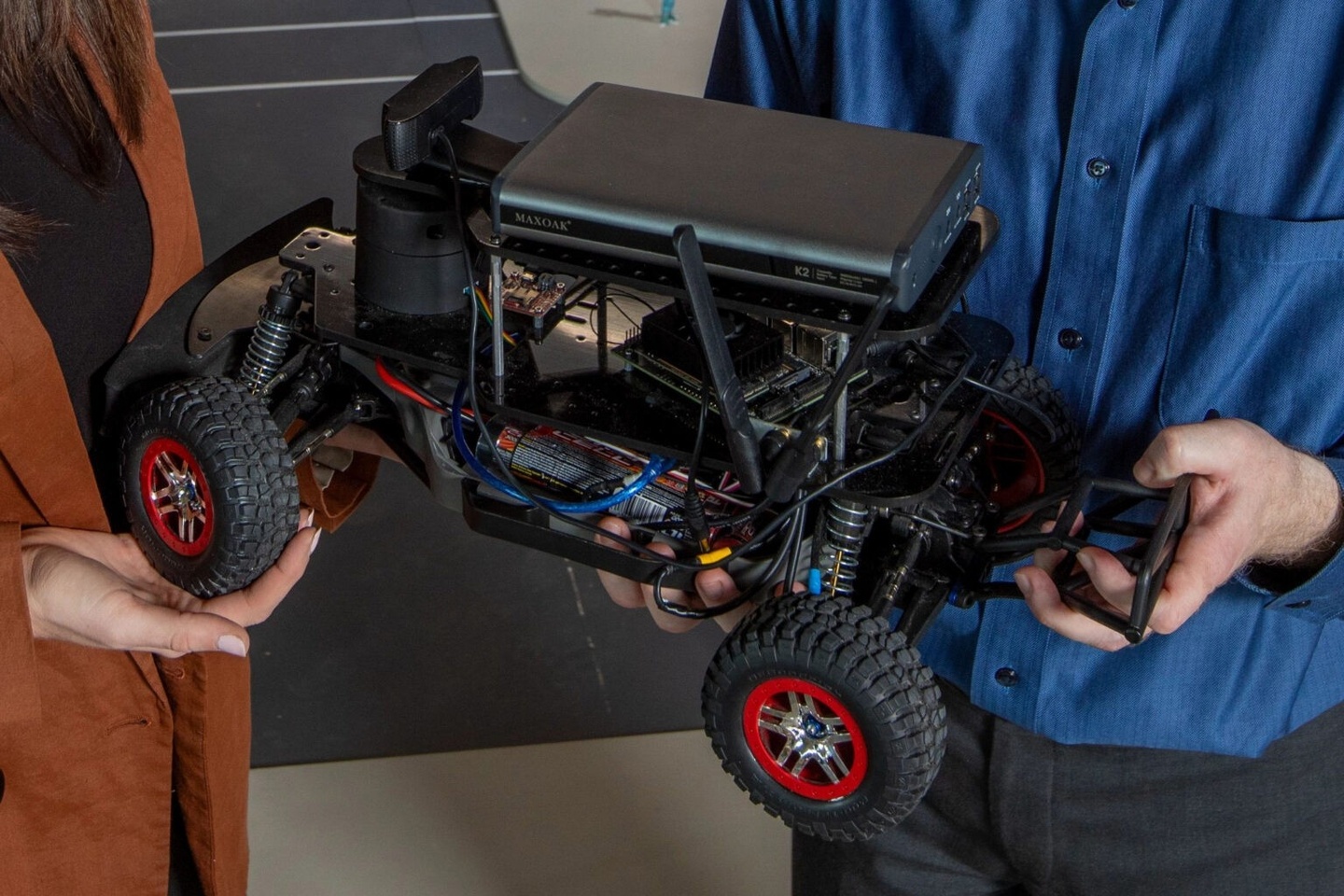 Two professors holding a model car