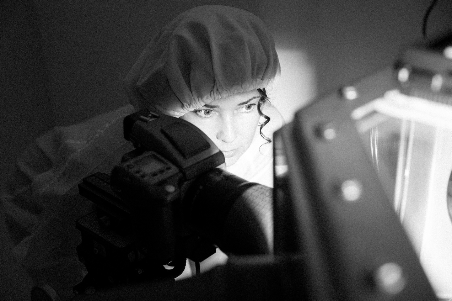 Black-and-white photo of Erika Blumenfeld photographing rocks at NASA’s cleanroom laboratory inside nitrogen cabinets.