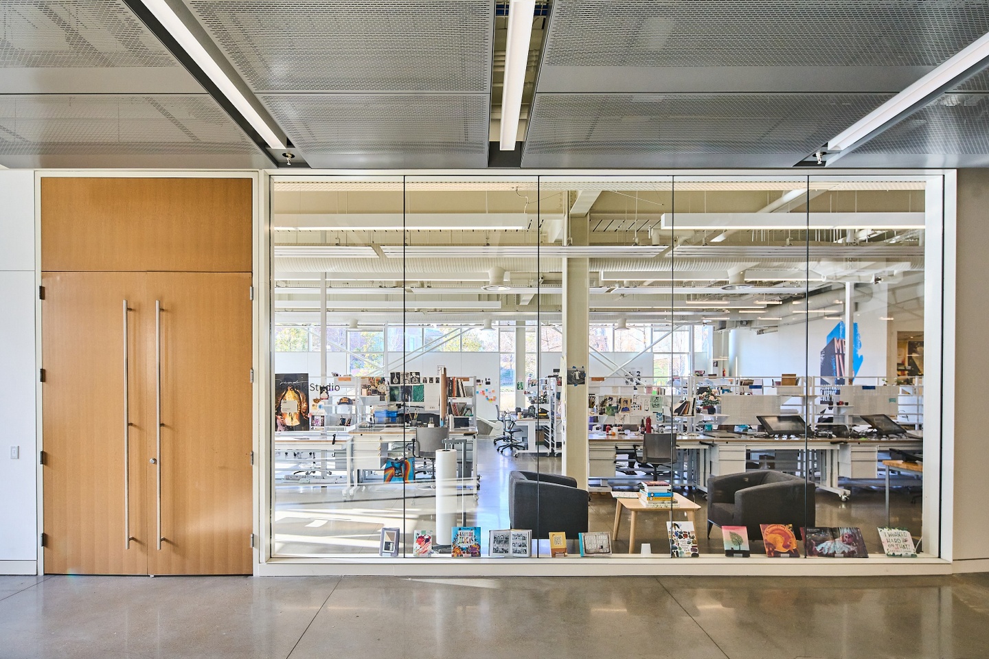 Image of illustration studio from interior hallway with closed double doors and a glass wall.