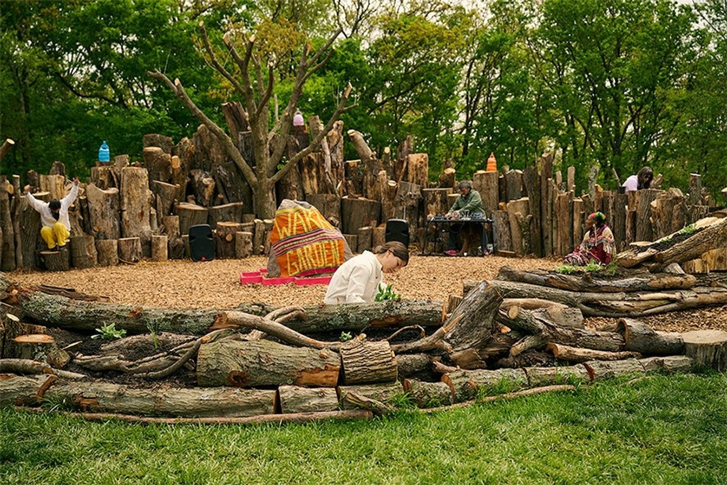 a person in the middle of a garden with a log fence