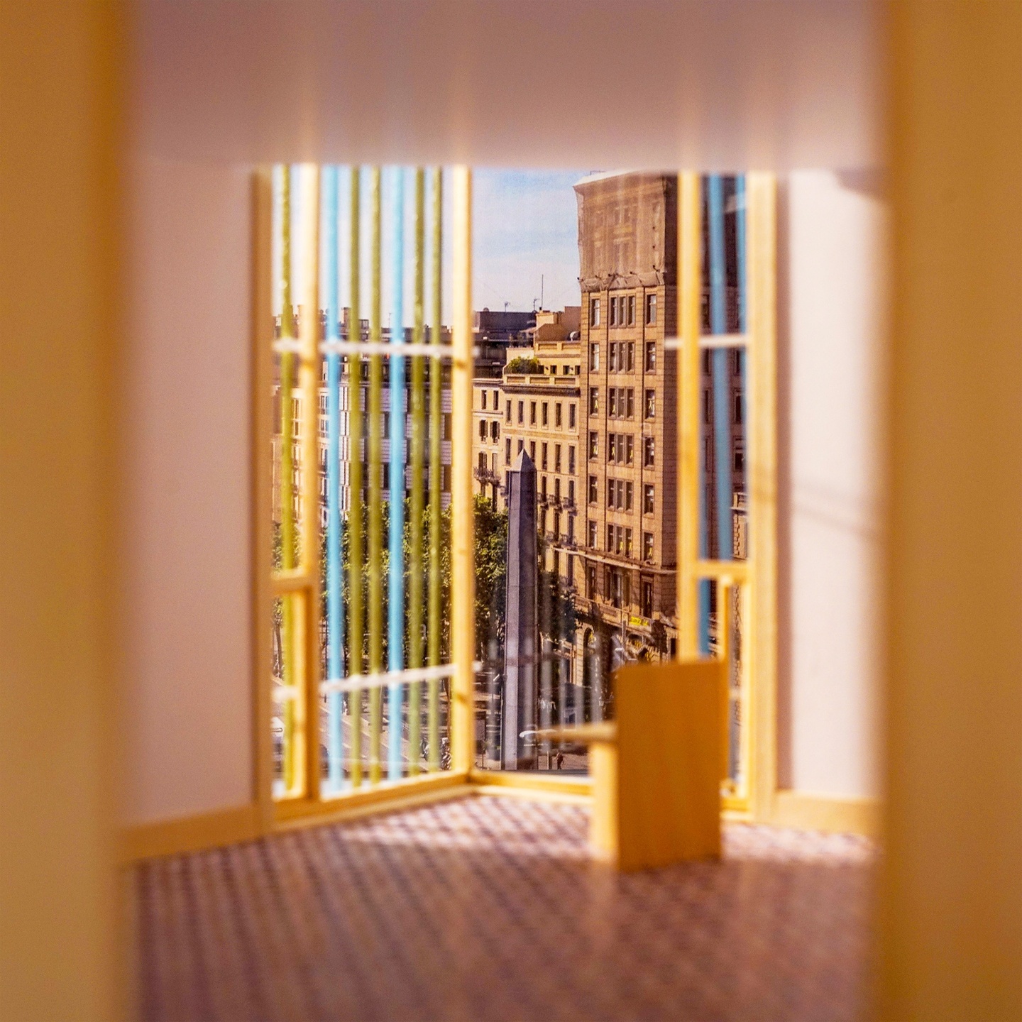 Photo collage in warm colors depicting a blurred interior building model with the vertical screening system showing a photo view of the site beyond with trees and multistory buildings.