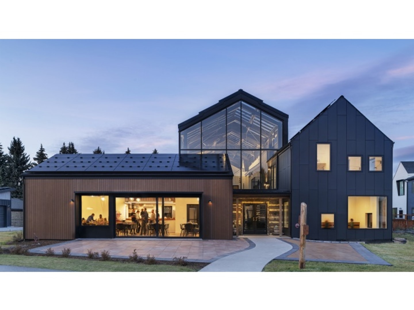 Exterior view of a home at dusk with the interior lights on.