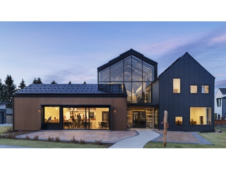 Exterior view of a home at dusk with the interior lights on.