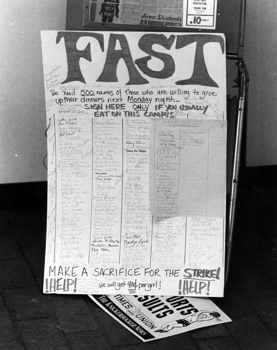 A black and white photograph of a large poster with “FAST” written at the top in large handwritten letters. Below, hundreds of signatures fill several columns.