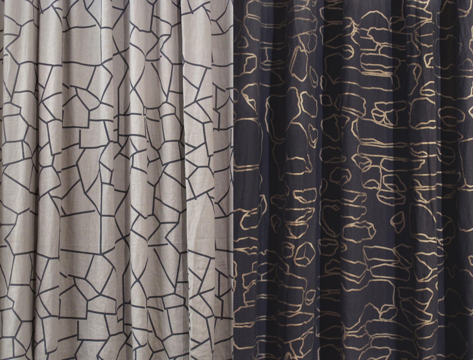 a detail of tan and dark blue curtains with a gold geometric line pattern