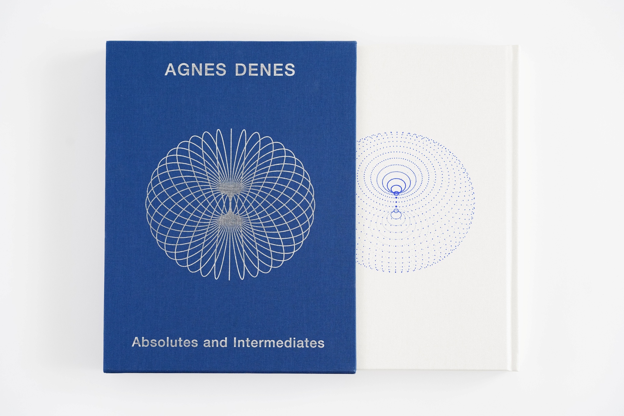 A white book halfway out of a blue slipcase decorated with a doughnut form